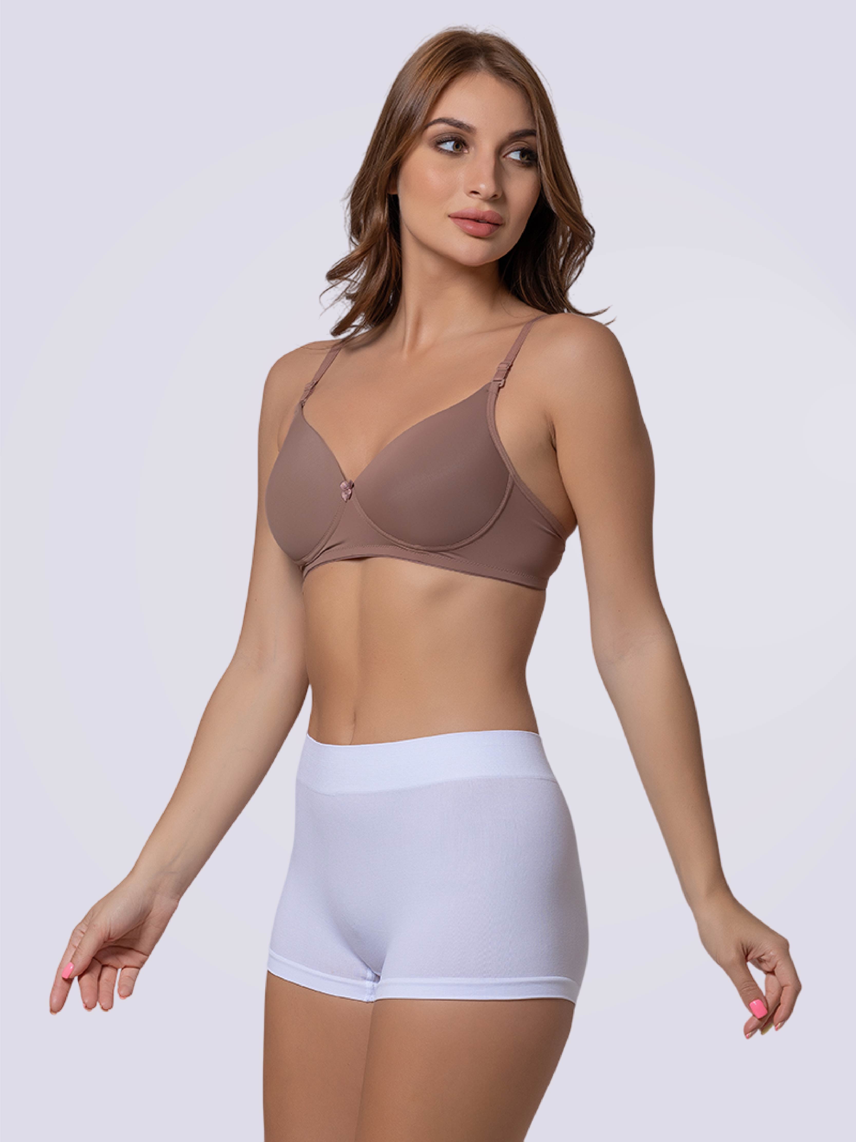 Woman wearing a brown bra and white shorts on a plain background